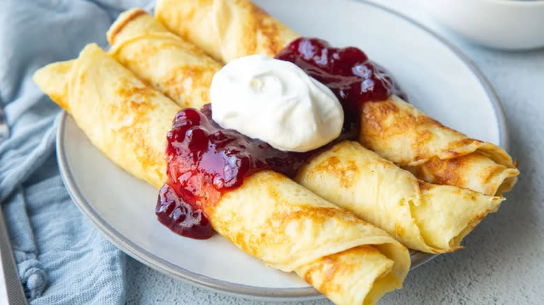 Pancakes with fruit jelly and cream or sour cream