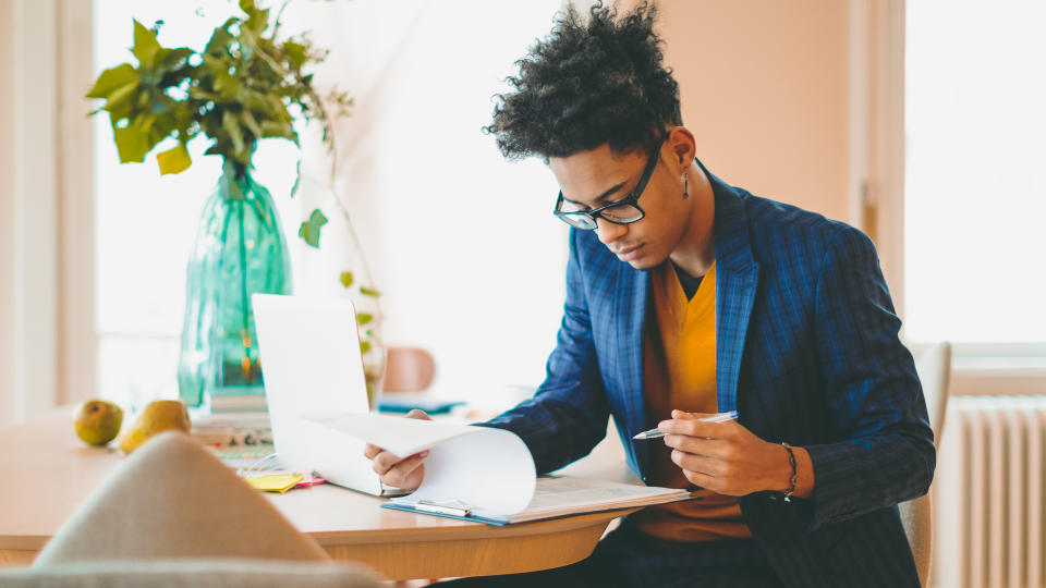 Young man is making a budget at home.