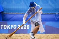 A member of the grounds crew rakes the sand before a men's beach volleyball match at the 2020 Summer Olympics, Tuesday, July 27, 2021, in Tokyo, Japan. (AP Photo/Petros Giannakouris)