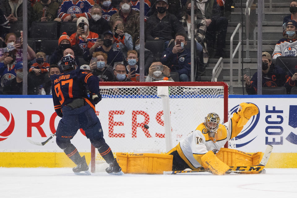 Nashville Predators' goalie Juuse Saros (74) is scored on by Edmonton Oilers' Connor McDavid (97) during the shootout of an NHL hockey game, Thursday, Jan. 27, 2022 in Edmonton, Alberta. (Jason Franson/The Canadian Press via AP)