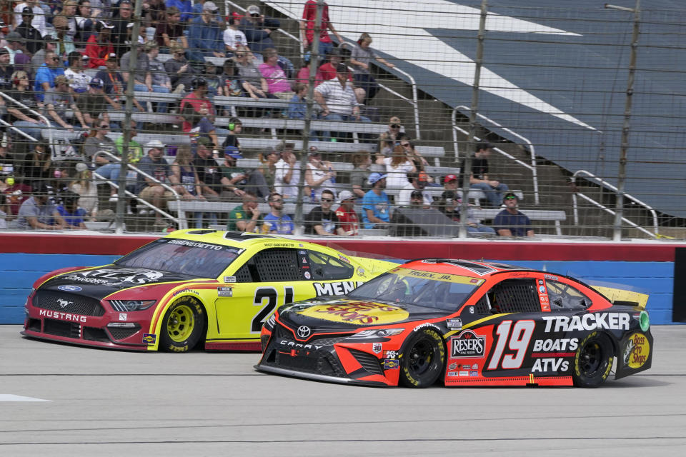 Martin Truex Jr. (19) drives alongside Matt Dibenedetto (21) during a NASCAR Cup Series auto race at Texas Motor Speedway Sunday, Oct. 17, 2021, in Fort Worth, Texas. (AP Photo/Larry Papke)