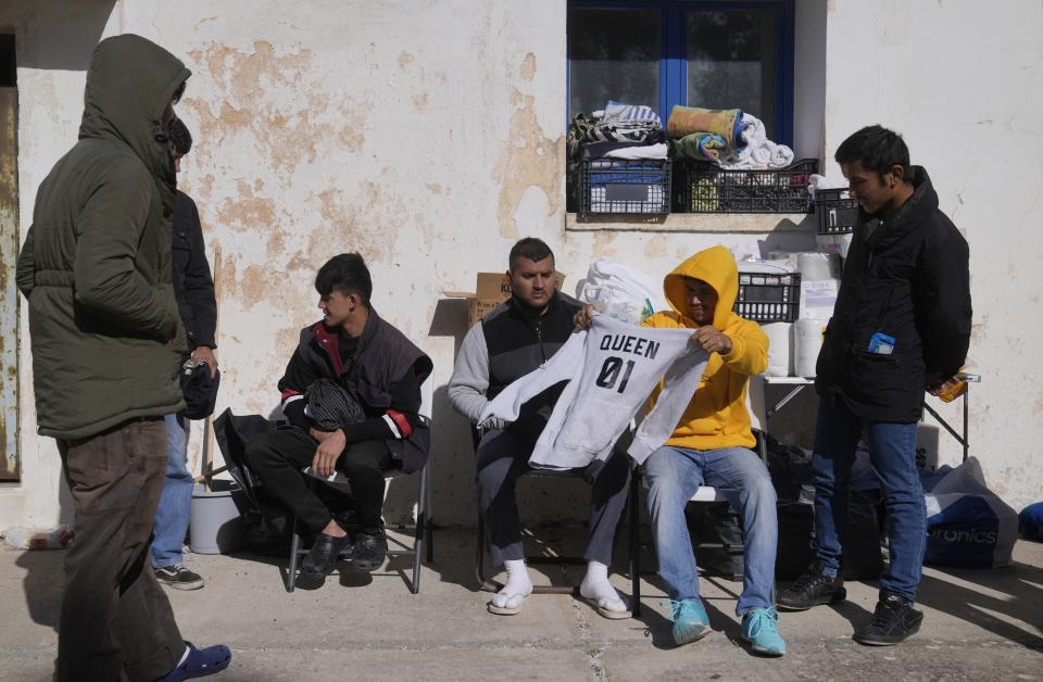 Migrants from Afghanistan rest at an old school used as a temporary shelter on the island of Kythira, southern Greece, Friday, Oct. 7, 2022. Strong winds were hampering rescue efforts at two Greek islands Friday for at least 10 migrants believed to be missing after shipwrecks left more than 20 people dead, officials said. (AP Photo/Thanassis Stavrakis)