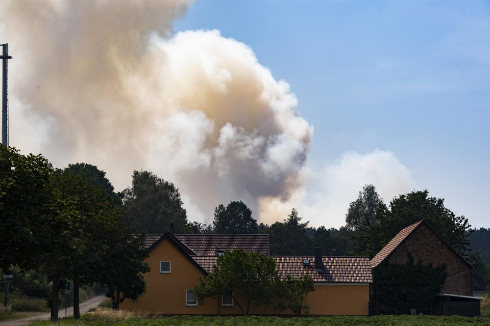 A cloud of smoke can be seen from afar not far from the district of Frohnsdorf, Germany, Sunday, June 19, 2022. There, the fire department has been fighting a forest fire for days. (Paul Zinken/dpa/dpa via AP)