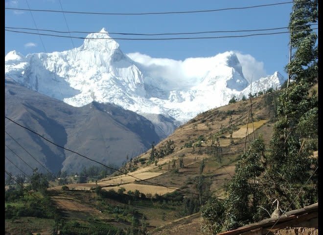 Glaciers of the Cordillera Blanca range loom above the small town of Mizac, Ancash, Peru.