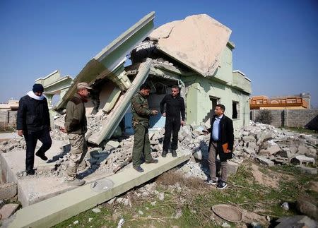 Sunni Arab fighters gather at a house, which belonged to an Iraqi soldier and was destroyed by Islamic State militants, in Rfaila village in the south of Mosul, Iraq, February 17, 2017. Picture taken February 17, 2017. REUTERS/Khalid al Mousily