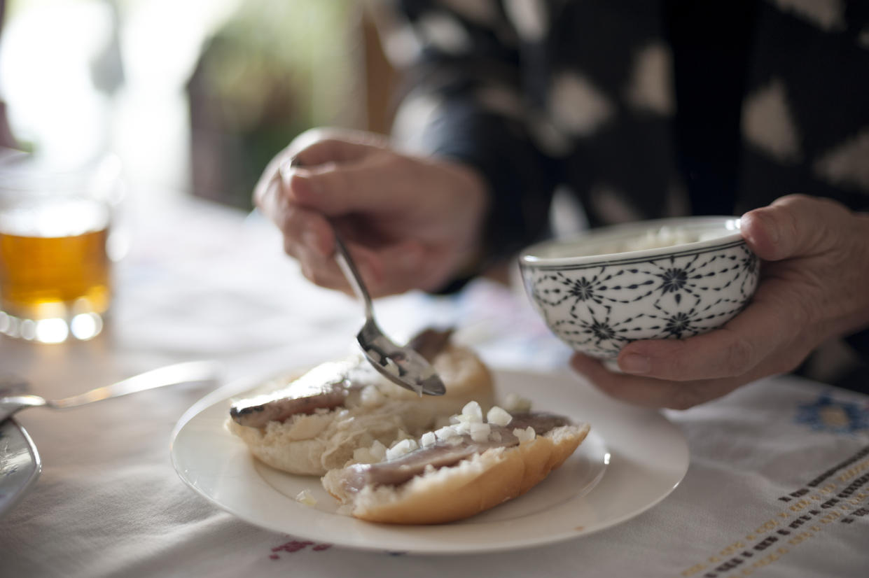 Diner spooning condiments onto plate of food