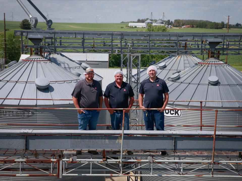 Jolly Time Popcorn employees, from left, Roger Bremmer, Jeff Naslund and Daniel Bloyer on top of the grain bins in Schaller.