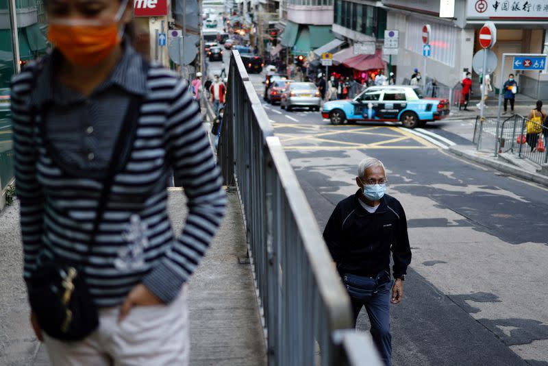 People wear masks following the coronavirus disease (COVID-19) outbreak, at the financial Central district in Hong Kong