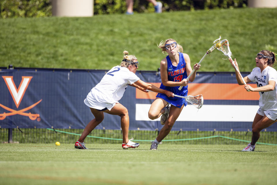 This photo provided by UAA Communications shows Florida attacker Maggi Hall, center, playing against Virginia in the second round of the NCAA women's lacrosse tournament, Sunday, May 12, 2024, in Charlottesville, Va. The unseeded Gators (20-2) are looking to crash a final four party typically reserved for traditional lacrosse powers. They play top-seeded and defending national champion Northwestern in the first semifinal Friday in Cary, North Carolina. No. 2 seed Boston College and third-seeded Syracuse square off in the other. (UAA Communication/Keith Lucas)