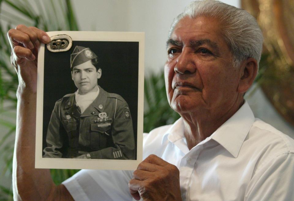 2003: Angel Romero was a 19-year-old paratrooper in the 82nd Airborne Division when he jumped into France on June 6, 1944. The retired soldier shows a photo of himself taken a year after his two combat jumps.