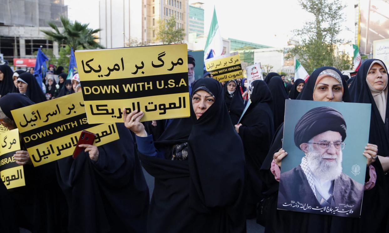 <span>Iranians hold signs and a portrait of the supreme leader, Ayatollah Ali Khamenei, in a celebration after the missile and drone attack on Israel, in Palestine Square, central Tehran, on Monday.</span><span>Photograph: Atta Kenare/AFP/Getty Images</span>