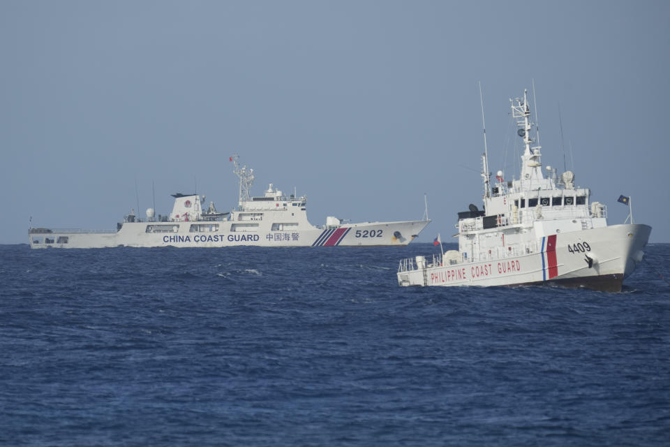 A Chinese coast guard vessel, left, passes by a Philippine coast guard ship near the Philippine-occupied Thitu island, locally called Pag-asa island, on Friday, Dec. 1, 2023 at the disputed South China Sea. The Philippine coast guard inaugurated a new monitoring base Friday on a remote island occupied by Filipino forces in the disputed South China Sea as Manila ramps up efforts to counter China's increasingly aggressive actions in the strategic waterway. (AP Photo/Aaron Favila)