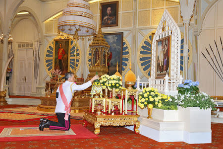 Thailand's new King Maha Vajiralongkorn Bodindradebayavarangkun pays respect to a picture of Thailand's late King Bhumibol Addlyadej and Queen Sirikit, as he accepts an invitation from parliament to succeed his father, at Bangkok's Dusit Palace in Bangkok, Thailand, December 1, 2016. Thailand Royal Household Bureau/Handout via REUTERS.