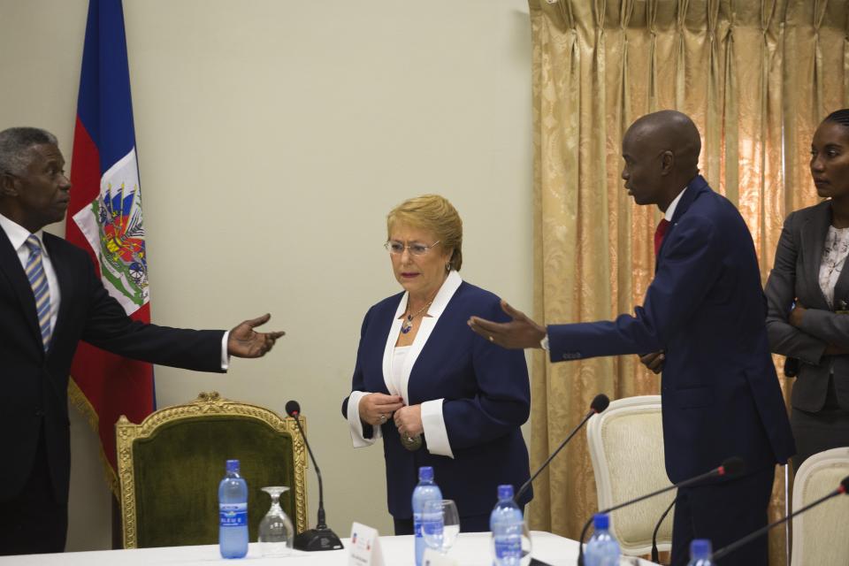 Haiti's President Jovenel Moise, right, arrives with Chile's President Michelle Bachelet, center, for a meeting at the National Palace in Port-au-Prince, Haiti, Monday, March 27, 2017. (AP Photo/Dieu Nalio Chery)