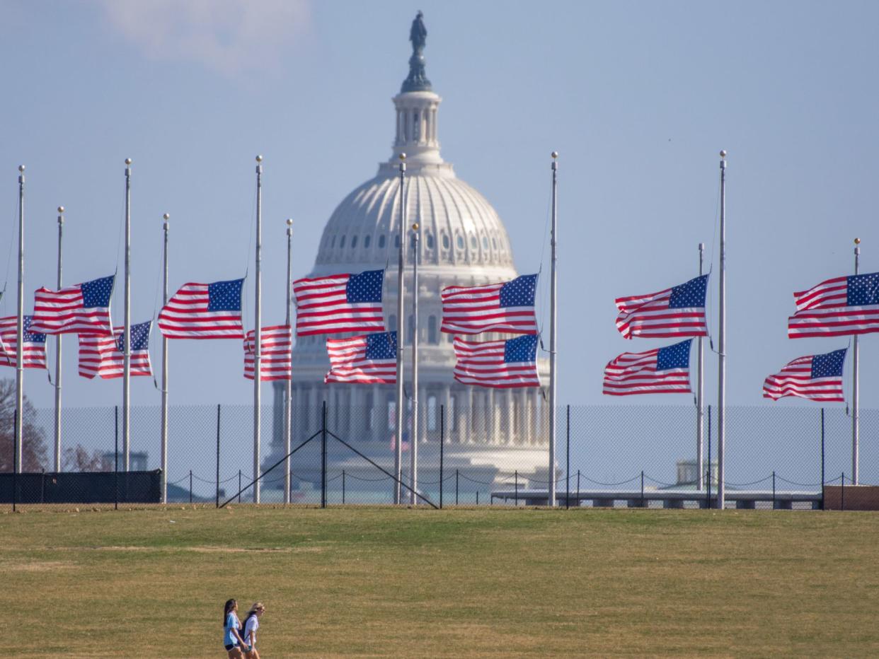 At the Washington Monument flags fly at half staff in mourning for the victims of the mass shootings at Marjory Stoneman Douglas High School in Parkland, Florida. Dome of the US Capitol is in background.