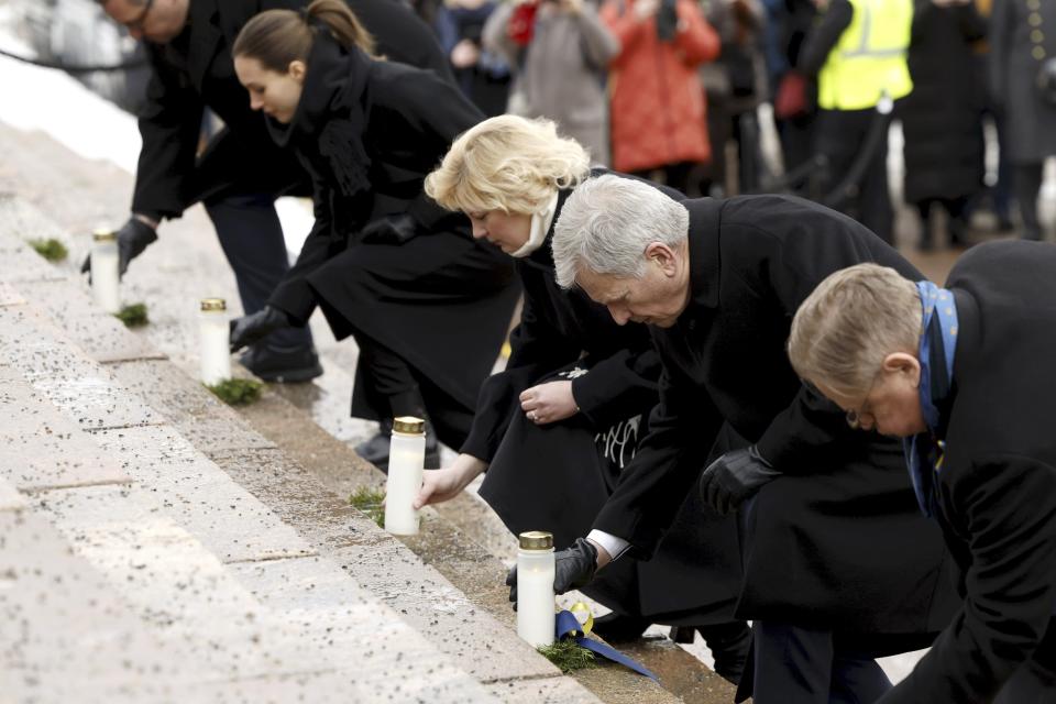 Finland's Prime Minister Sanna Marin, 2nd left, Ukrainian Ambassador to Finland Olga Dibrova, center, Finnish President Sauli Niinist', 2nd right, and Helsinki Mayor Juhana Vartiainen (right) place candles on the steps of the Helsinki Cathedral at the Light for Ukraine candlelight memorial event for Ukraine war victims at the Senate Square in Helsinki, Finland, Friday Feb. 24, 2023. (Roni Rekomaa/Lehtikuva via AP)