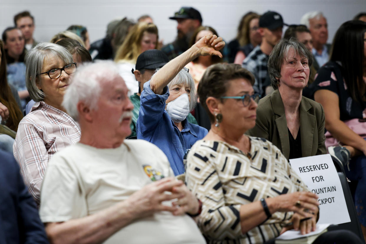 Woodland Park resident Gail Gerig, center, makes a thumbs down gesture during the public comment period of the Woodland Park School District Board of Education meeting on April 12, 2023 in Woodland Park, Colo. (Michael Ciaglo for NBC News)