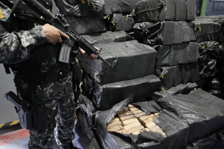 Policías custodian droga incautada en varios operativos policiales para ser incinerada en Cayambe, Ecuador, el jueves 21 de abril de 2022. (Foto AP/Dolores Ochoa)