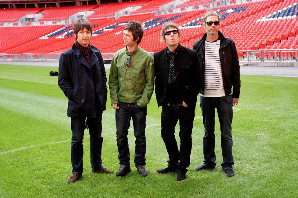 Gem Archer, Noel Gallagher, Liam Gallagher and Chris Sharrock on the pitch at Wembley Stadium