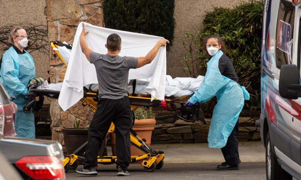 Healthcare workers transport a patient on a stretcher into an ambulance at Life Care Center of Kirkland in Kirkland, Washington on February 29th.