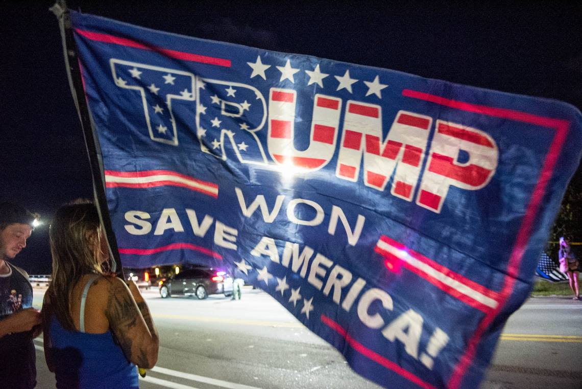 Lydia Hanson of West Palm Beach, Florida, holds a Trump flag near Mar-A-Lago, former President Donald Trump’s residence, in March. Trump convinced his voters that Democrats used tools such as mail ballots to steal the 2020 election. ANDRES LEIVA/PALM BEACH POST/USA TODAY NETWORK