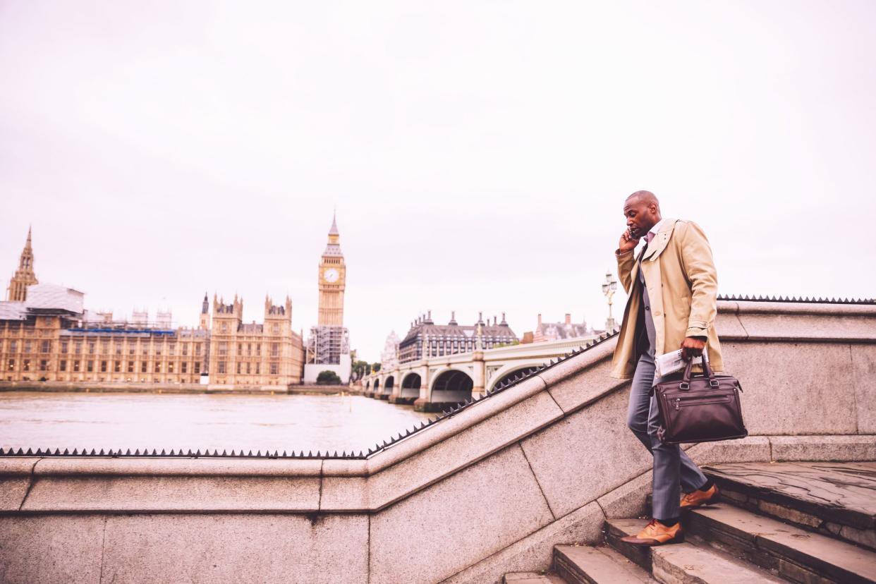 London, Businessman, Confidence, England -  Busy Business Executive walking down the Westminster Bridge talking on the phone during his morning commute