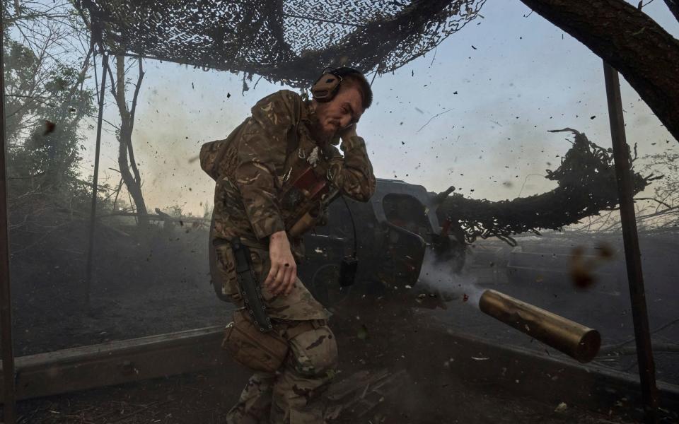 A Ukrainian serviceman of the 10th Assault Brigade Edelweiss fires a D-30 cannon towards Russian positions at the front line near Bakhmut