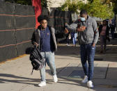 Students bump elbows as they arrive for the first day of in-person classes at Erasmus High School in Brooklyn's Flatbush neighborhood, Thursday, Oct. 1, 2020 in New York. The city's plans to send kids back into classrooms rely on an ambitious plan to do random virus testing of pupils and staff throughout the school year. (AP Photo/Mark Lennihan)