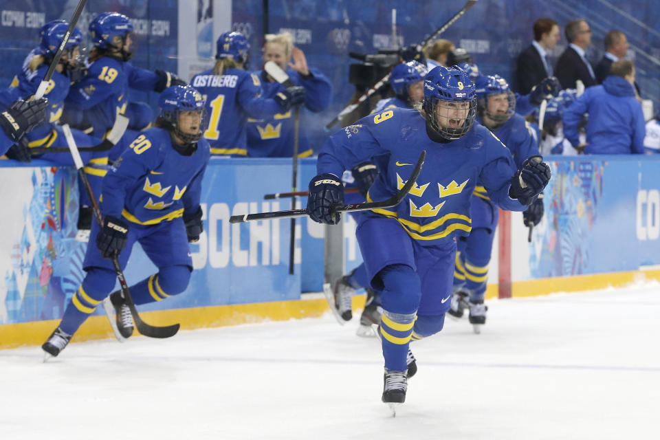 Josefine Holmgren of Sweden leads her teammates to the ice after Team Sweden's 4-2 victory of Finland in the 2014 Winter Olympics women's ice hockey quarterfinal game at Shayba Arena, Saturday, Feb. 15, 2014, in Sochi, Russia. (AP Photo/Petr David Josek)