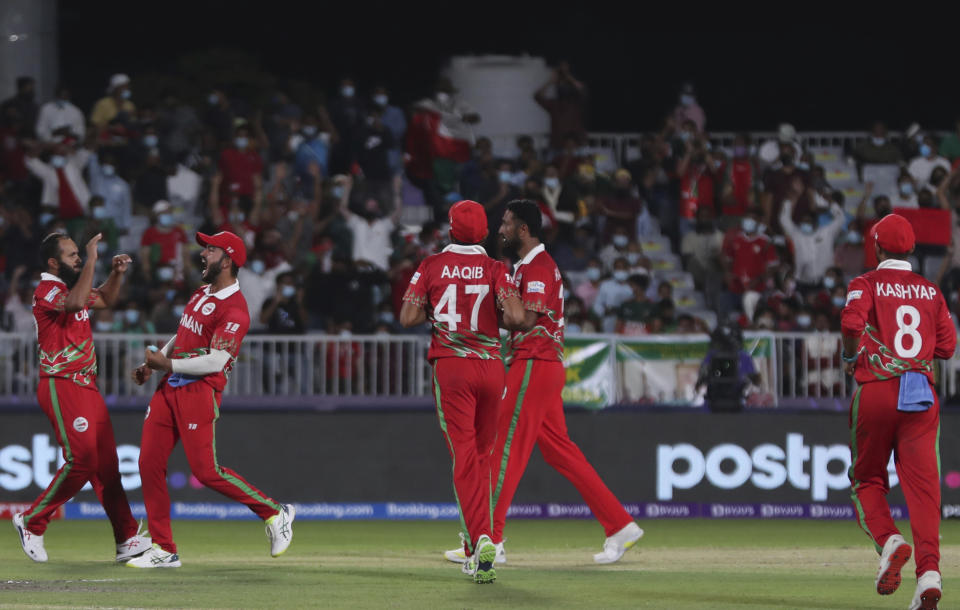 Oman's captain Mohammad Mahmudullah, second from left, celebrates with teammates after dismissing Bangladesh's batsman Afif Hossain for 1 run during the Cricket Twenty20 World Cup first round match between Oman and Bangladesh in Muscat, Oman, Tuesday, Oct. 19, 2021. (AP Photo/Kamran Jebreili)