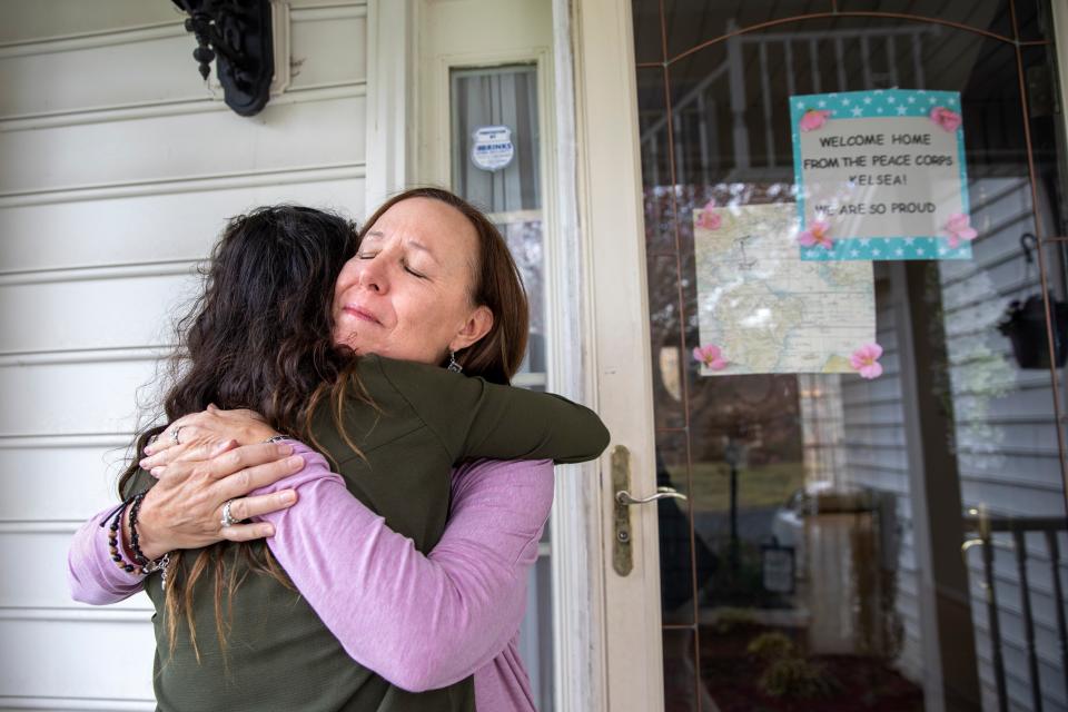 Holly Balcom, 54, hugs her daughter Kelsea Mensh, 22, as they reunite at their home in Dumfries, Va., Wednesday, April 1, 2020, after Mensh, who had served a year in the Peace Corps in the Dominican Republic, finished her 2 week quarantine period. After evacuating her from her post, the Peace Corps put Mensh up in a hotel in her hometown to self-isolate so that she wouldn't cause any risk to her mother, who is a cancer survivor and has viral induced asthma. Though she is grateful to have been evacuated, "I didn't get to say goodbye," says Mensh, who is very worried about the community she had to leave in the Dominican Republic, "I told my mother that in tears and we both started to cry. She said, 'I didn't get to say goodbye to the children here either.'" Balcom is a fourth grade teacher. (AP Photo/Jacquelyn Martin)