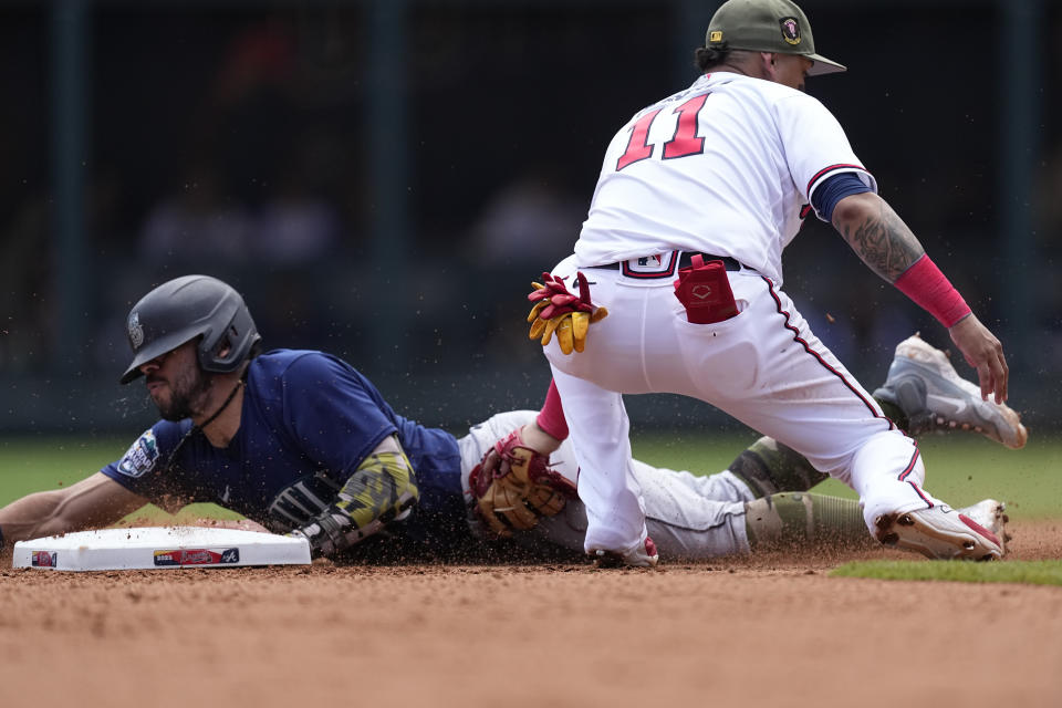 Seattle Mariners' Jose Caballero (76) beats the tag from Atlanta Braves shortstop Orlando Arcia (11) as he steals second base in the sixth inning of a baseball game, Sunday, May 21, 2023, in Atlanta. (AP Photo/John Bazemore)