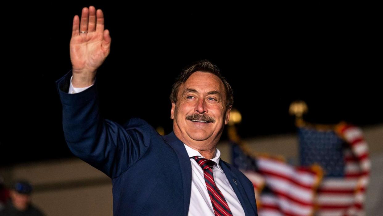 PHOTO: MyPillow CEO Mike Lindell waves as he is introduced while former U.S. President Donald Trump speaks during a campaign event at Sioux Gateway Airport, Nov. 3, 2022, in Sioux City, Iowa. (Stephen Maturen/Getty Images)