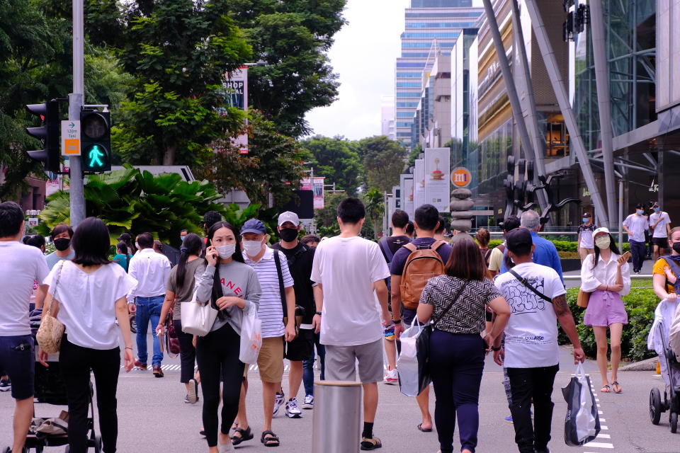 Singapore Sep2020 People wearing face masks crossing a road (selective focus). Crowd picks up in Orchard Road during Phase 2 after circuit breaker; Covid-19 coronavirus outbreak