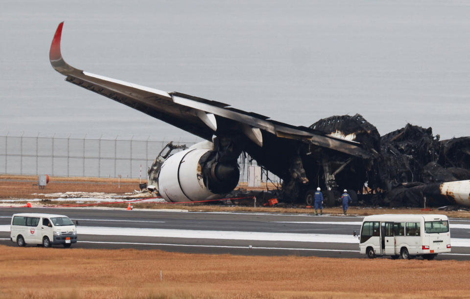 Officials investigate a burnt Japan Airlines (JAL) Airbus A350 plane after a collision with a Japan Coast Guard aircraft at Haneda International Airport in Tokyo, Japan January 3, 2024. REUTERS/Issei Kato