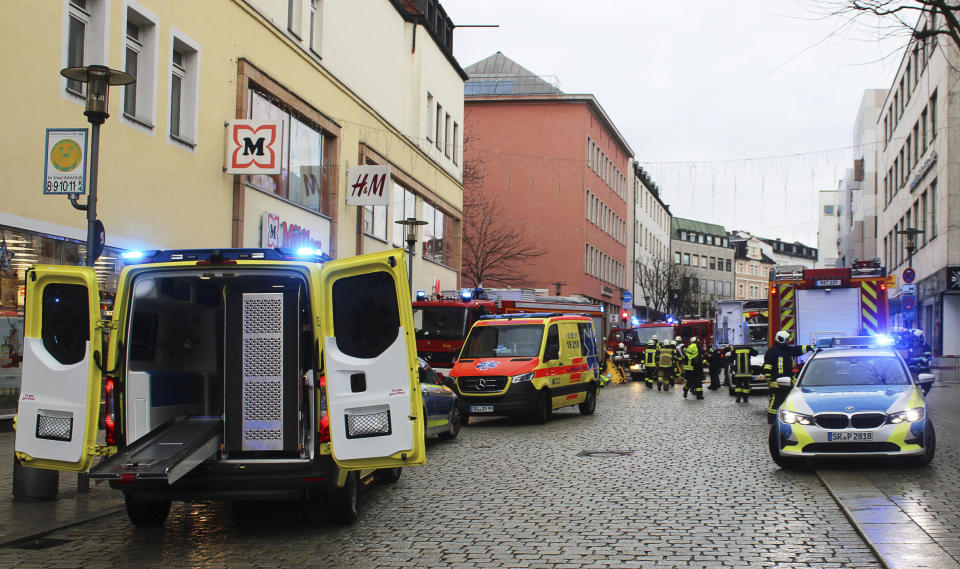 Emergency services from the police, fire department and ambulance stand at the scene of an accident in the city center in Passau, Germany, Friday Dec. 29, 2023. A deadly truck crash in southern Germany on Friday left one person dead, German police said. The 63-year old truck driver continued his ride after making a delivery in downtown Passau close to the city’s railway station, passed by a parked vehicle and then hit a group of five people. (Zema Medien/dpa via AP)