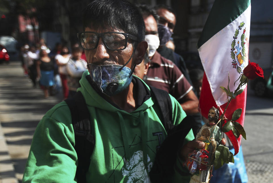 Faithful wearing protective face masks amid the new coronavirus, wait in line to enter the San Hipolito Catholic church as part of the annual pilgrimage honoring Saint Jude, the patron saint of lost causes, in Mexico City, Wednesday, Oct. 28, 2020. Thousands of Mexicans did not miss this year to mark St. Jude's feast day, but the pandemic caused Masses to be canceled and the rivers of people of other years were replaced by orderly lines of masked worshipers waiting their turn for a blessing. (AP Photo/Marco Ugarte)