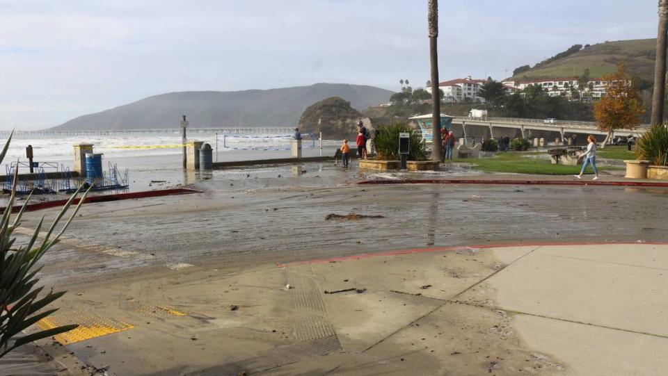 High surf runs all the way up Avila Beach to the sidewalk as visitors take in the sight on Thursday, Dec. 28 2023.