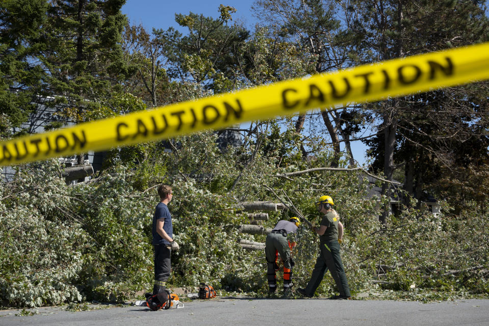 Workers clear fallen trees caused by post-tropical storm Fiona in Dartmouth, Nova Scotia, on Sunday, Sept. 25, 2022. Hundreds of thousands of people in Atlantic Canada remain without power and officials are trying to assess the scope of devastation from former Hurricane Fiona. It swept away houses, stripped off roofs and blocked roads across the country’s Atlantic provinces. (Darren Calabrese/The Canadian Press via AP)