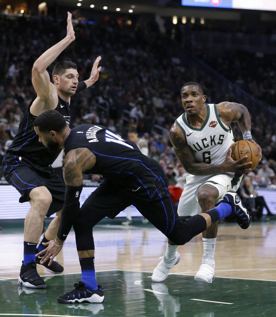 Milwaukee Bucks' Eric Bledsoe, right, drives to the basket past Orlando Magic's D.J. Augustin, middle, and Nikola Vucevic, left, during the second half of an NBA basketball game Saturday, Feb. 9, 2019, in Milwaukee. (AP Photo/Aaron Gash)