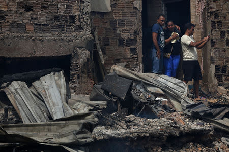 Residents are seen after a fire at Educandos neighbourhood, on a branch of the Rio Negro, a tributary to the Amazon river, in the city of Manaus, Brazil December 18, 2018. REUTERS/Bruno Kelly