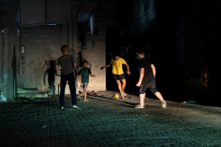 Children of Shati Refugee Camp playing football in the pitch black streets and alleyways of their neighbourhood using only the headlights of passing cars (Paddy Dowling)