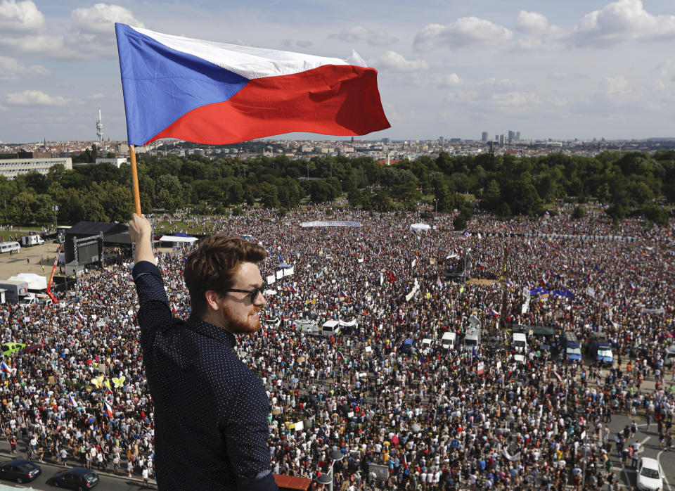 A man waves the Czech flag as people protest in Prague, Czech Republic, Sunday, June 23, 2019. Protesters are on calling on Czech Prime Minister Andrej Babis to step down over fraud allegations and subsidies paid to his former companies. (AP Photo/Petr David Josek)