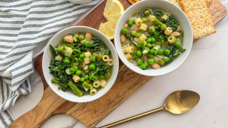 2 bowls of soup on board with crackers and lemon