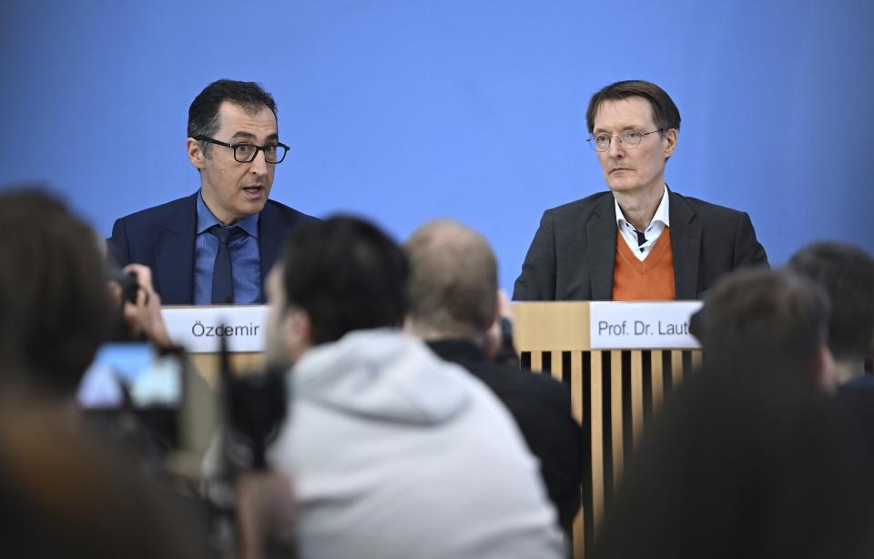 German Agriculture Minister Cem Ozdemir, left, and German Health Minister Karl Lauterbach, right, address the media during a press conference in Berlin, Germany, Wednesday, April 12, 2023. The German government on Wednesday presented scaled-back plans to liberalize the country's rules on cannabis, which would decriminalize possessing and growing limited amounts of the substance and allow its sale for recreational purposes to members of nonprofit 'cannabis clubs.' (Britta Pedersen/dpa via AP)