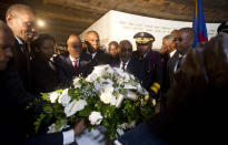 El presidente haitiano Jovenel Moïse, cuarto de izquierda a derecha, coloca flores frente a un monumento durante una ceremonia por el 215to aniversario de la Batalla de Vertieres en Puerto Príncipe, Haití, el domingo 18 de noviembre de 2018, tras la cual Haití se independizó de Francia. (AP Foto/Dieu Nalio Chery)