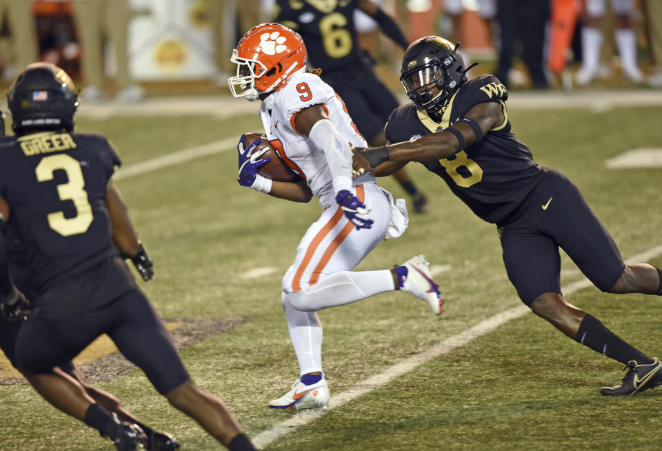 Clemson running back Travis Etienne gets past Wake Forest 's Ja'Cquez William (8) in the first half of an NCAA college football game Saturday, Sept. 12, 2020, in Winston-Salem, N.C. (Walt Unks/The Winston-Salem Journal via AP)