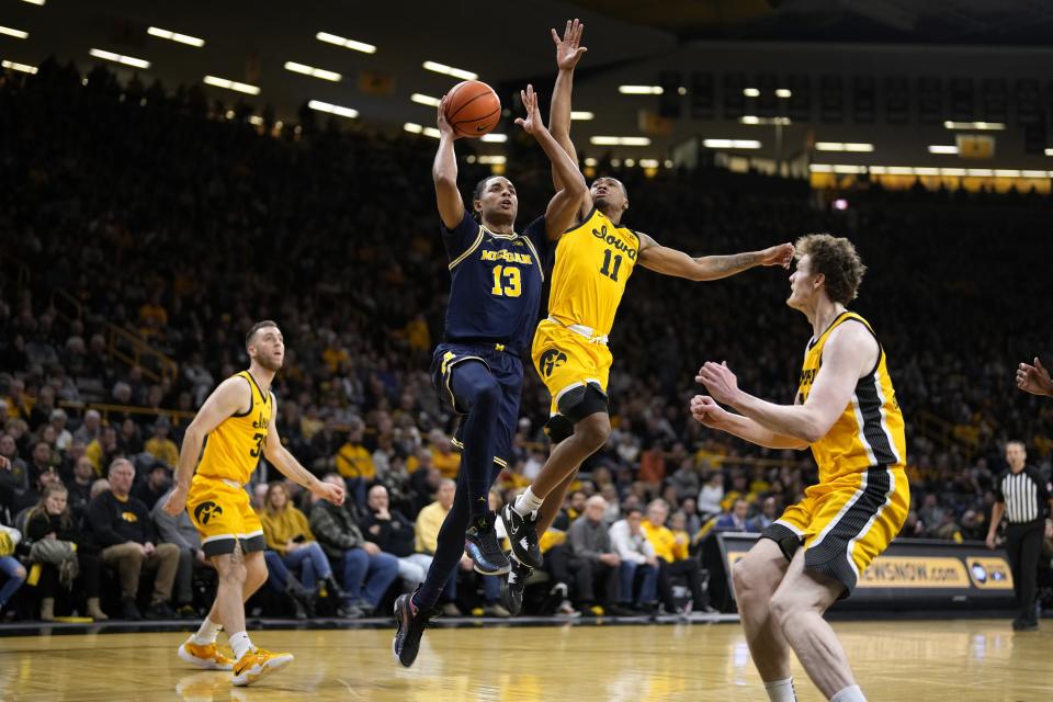 Michigan guard Jett Howard (13) drives to the basket past Iowa guard Tony Perkins (11) during the first half at Carver-Hawkeye Arena in Iowa City on Thursday, Jan. 12, 2023.