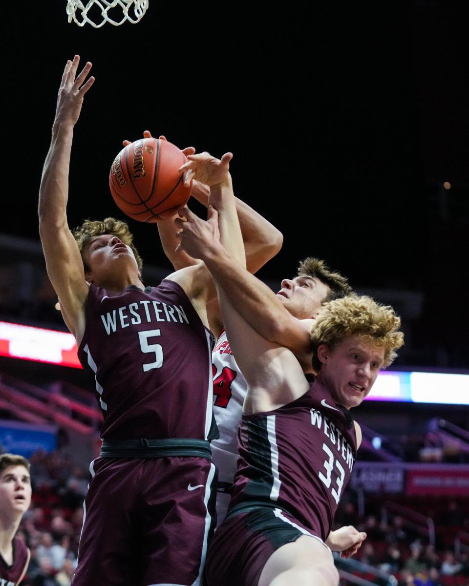 Roland-Story forward Luke Patton (34) goes up for a rebound against Western Christian guard Tyler Mantel (5) and forward Tate Van Regenmorter (33) during the class 2A semifinals of the Iowa high school boys state basketball tournament.