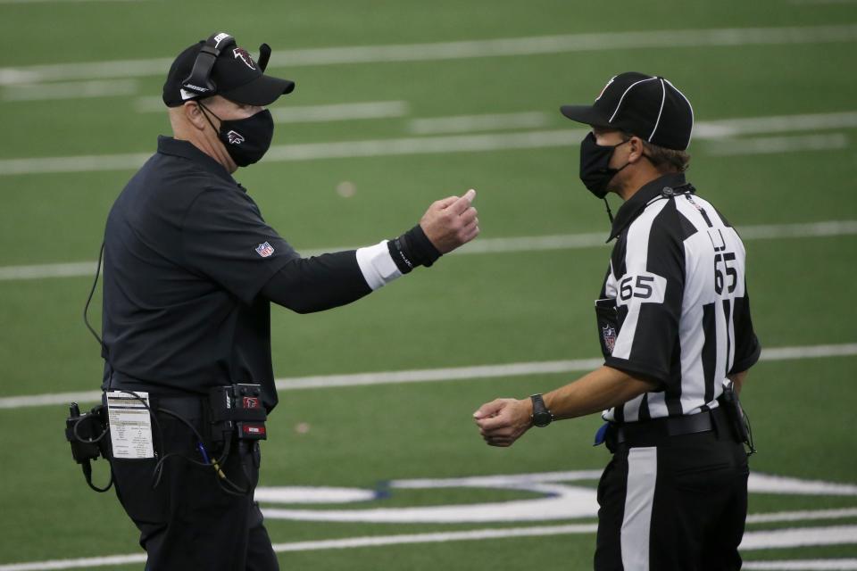 Atlanta Falcons head coach Dan Quinn talks with referee Walt Coleman (65) in the second half of an NFL football game against the Dallas Cowboys in Arlington, Texas, Sunday, Sept. 20, 2020. (AP Photo/Michael Ainsworth)